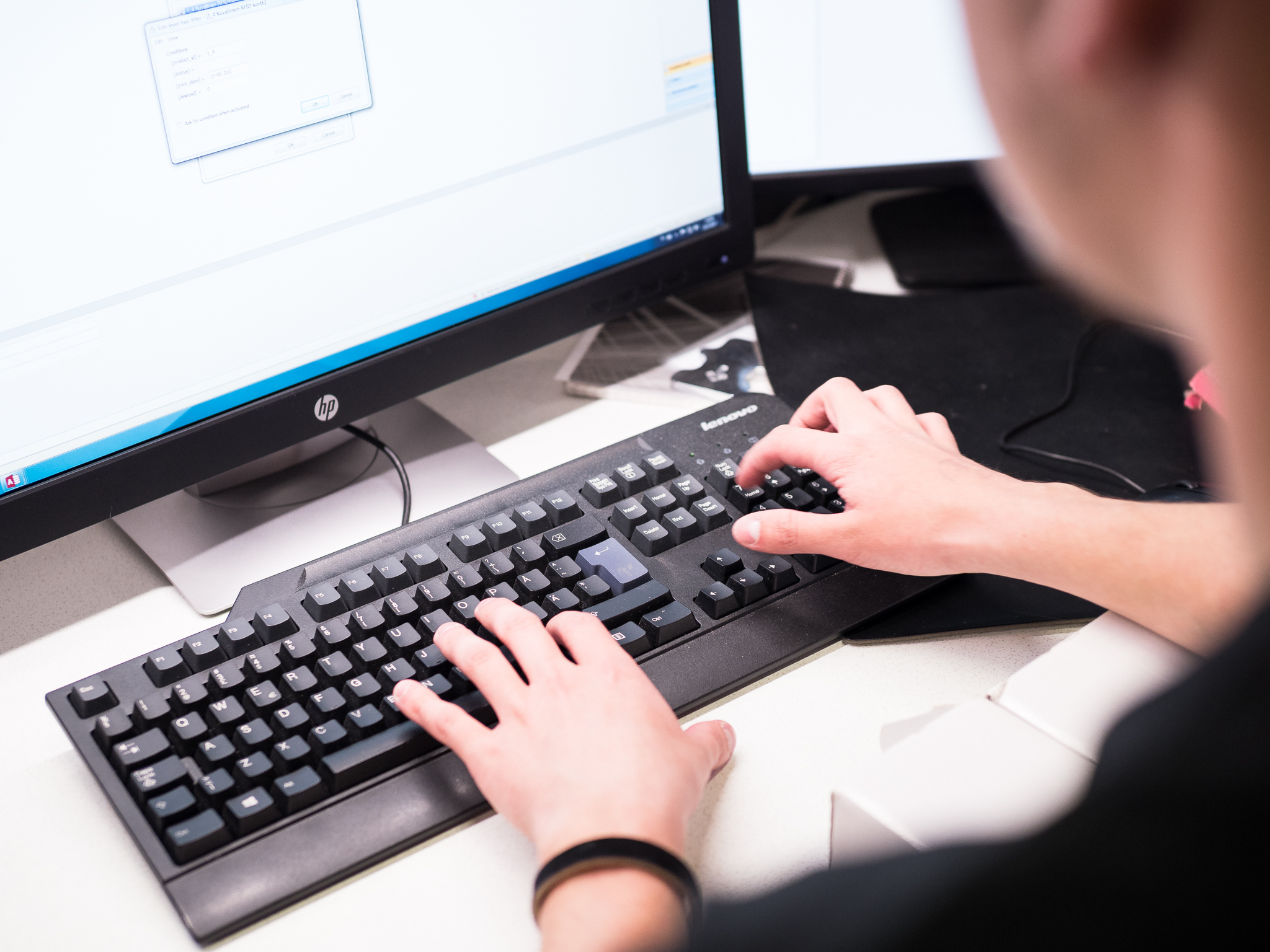 Henkilö kirjoittaa tietokoneella